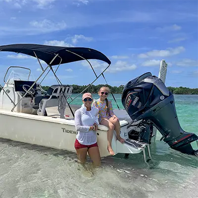 Girls leaning on boat at Marvin Key sandbar