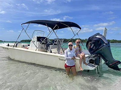 Girls leaning on boat at Marvin Key sandbar